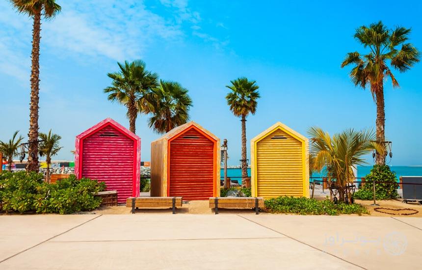 تصویری از ساحل لامر دبی که سه سازه چوبی رنگی را در کنار ساحل نشان می‌دهد